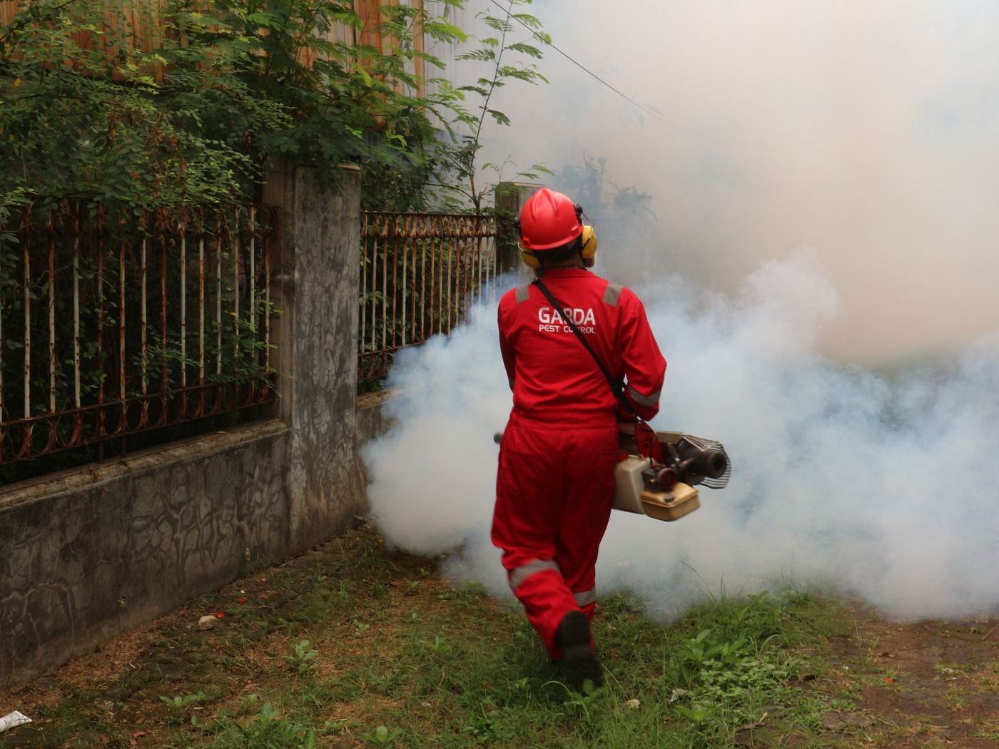 Technician fogging a backyard for mosquitoes