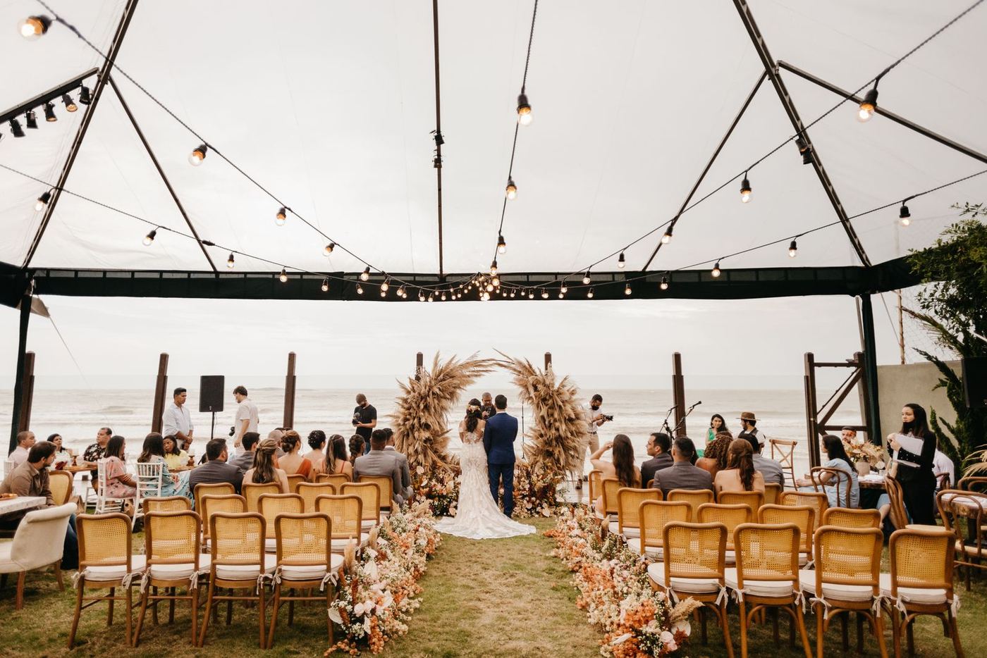 Outdoor wedding ceremony under a canopy by the sea